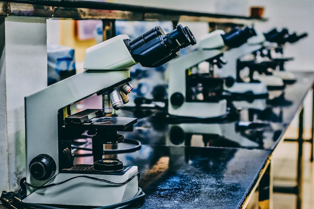 Microscópio branco em cima da mesa preta