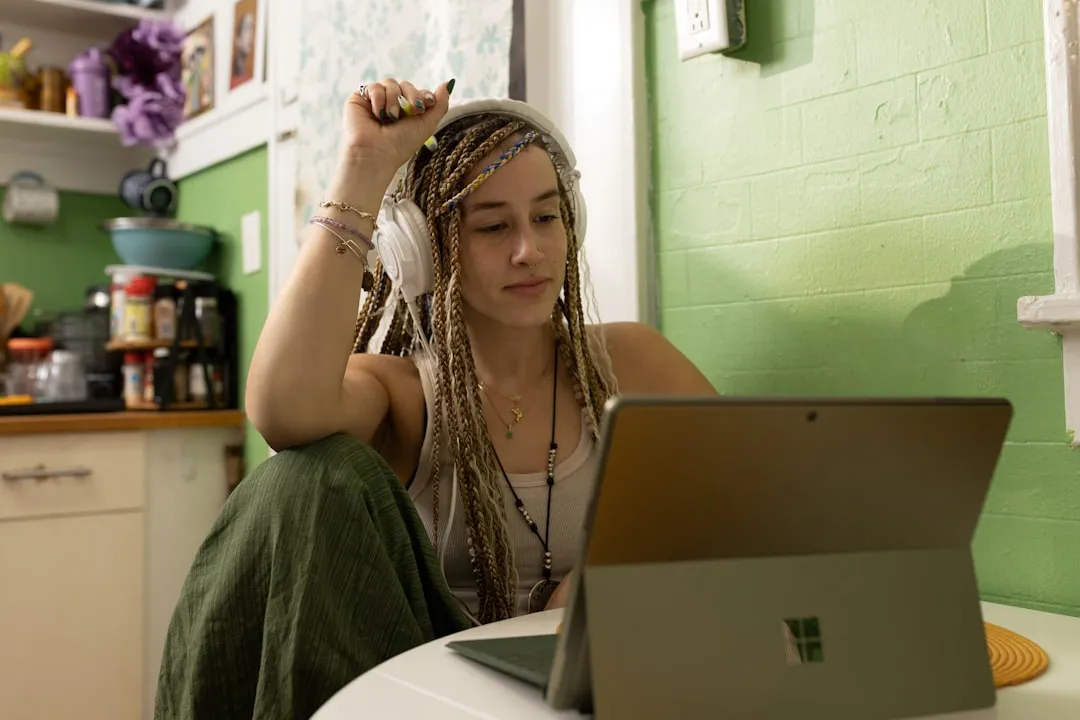Uma mulher com dreadlocks sentados em frente a um laptop