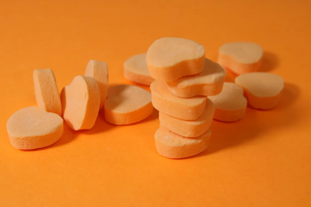 Uma pilha de pedaços de comida cortada em uma superfície laranja