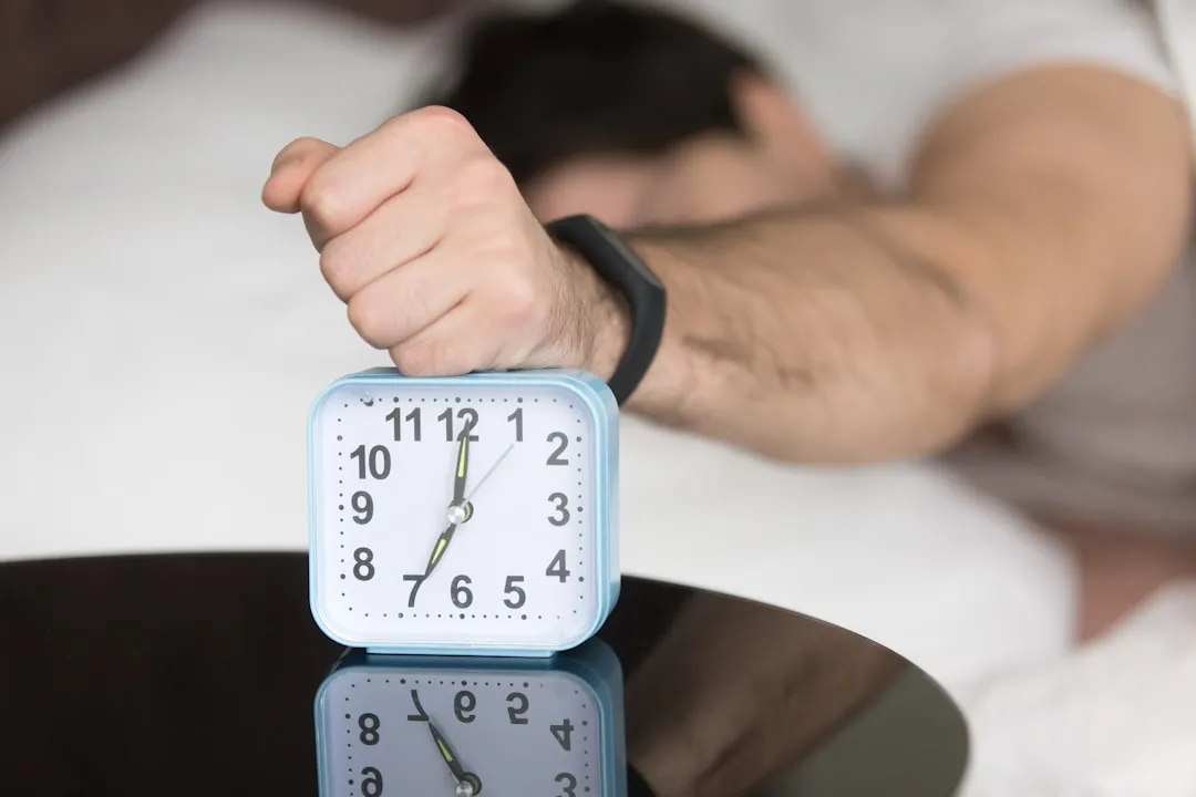 Um homem deitado na cama com um relógio em cima dele