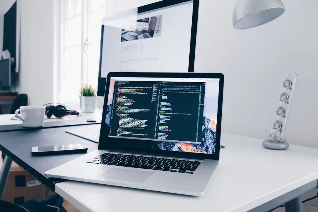 Um macbook com linhas de código em sua tela em uma mesa movimentada Um macbook com linhas de código em sua tela em uma mesa movimentada