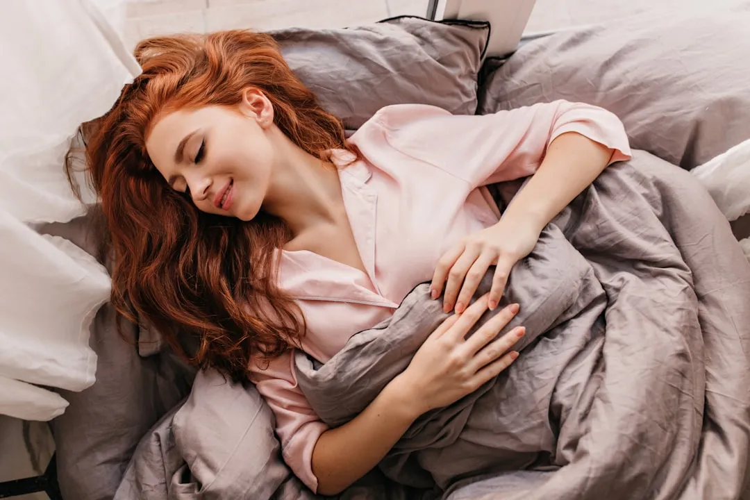 Uma mulher deitada em uma cama com um laptop