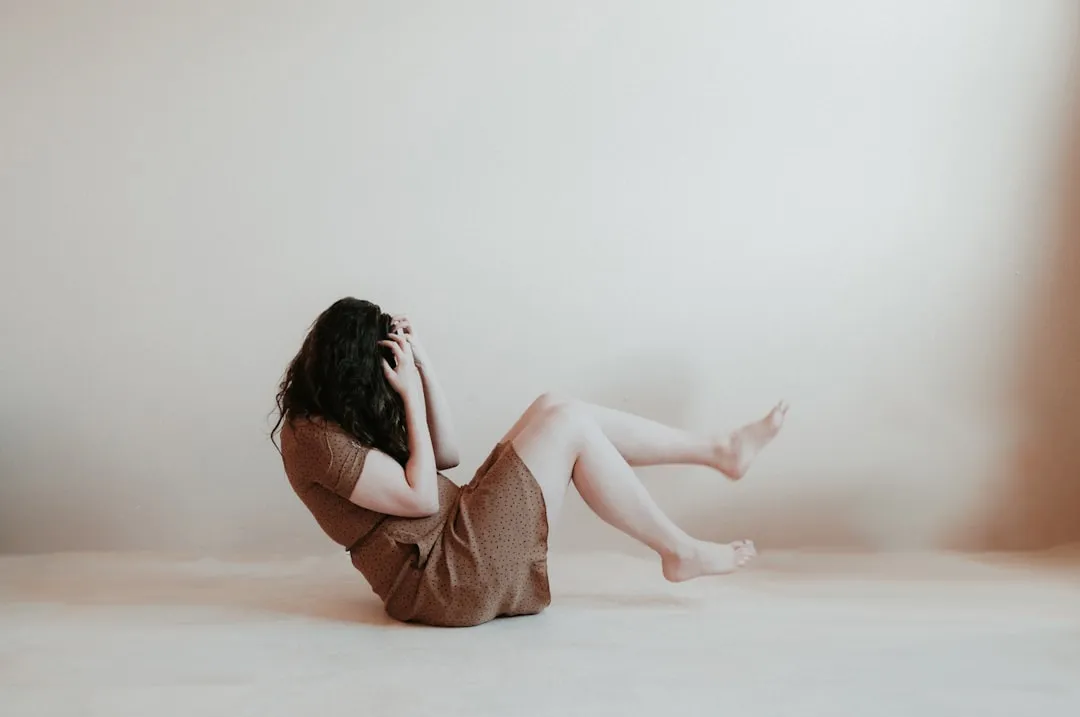 Mulher sentada no chão vestindo vestido marrom