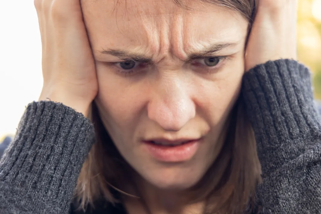 Um homem segurando a cabeça com as duas mãos Um homem segurando a cabeça com as duas mãos