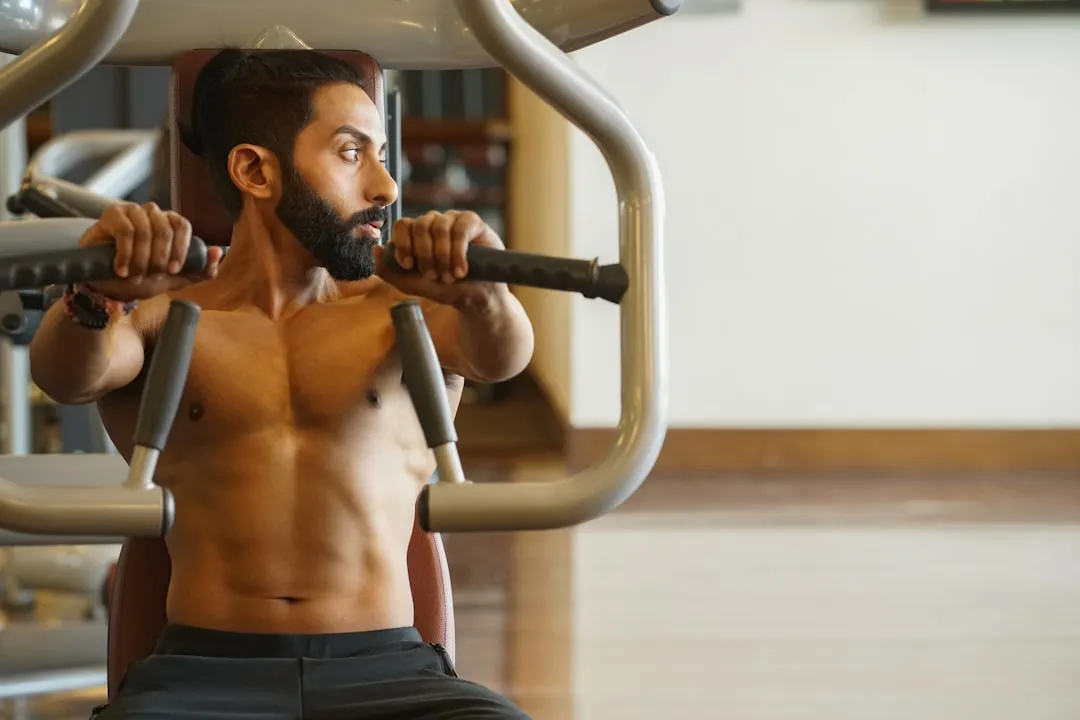 Homem sentado na máquina de exercícios Homem sentado na máquina de exercícios