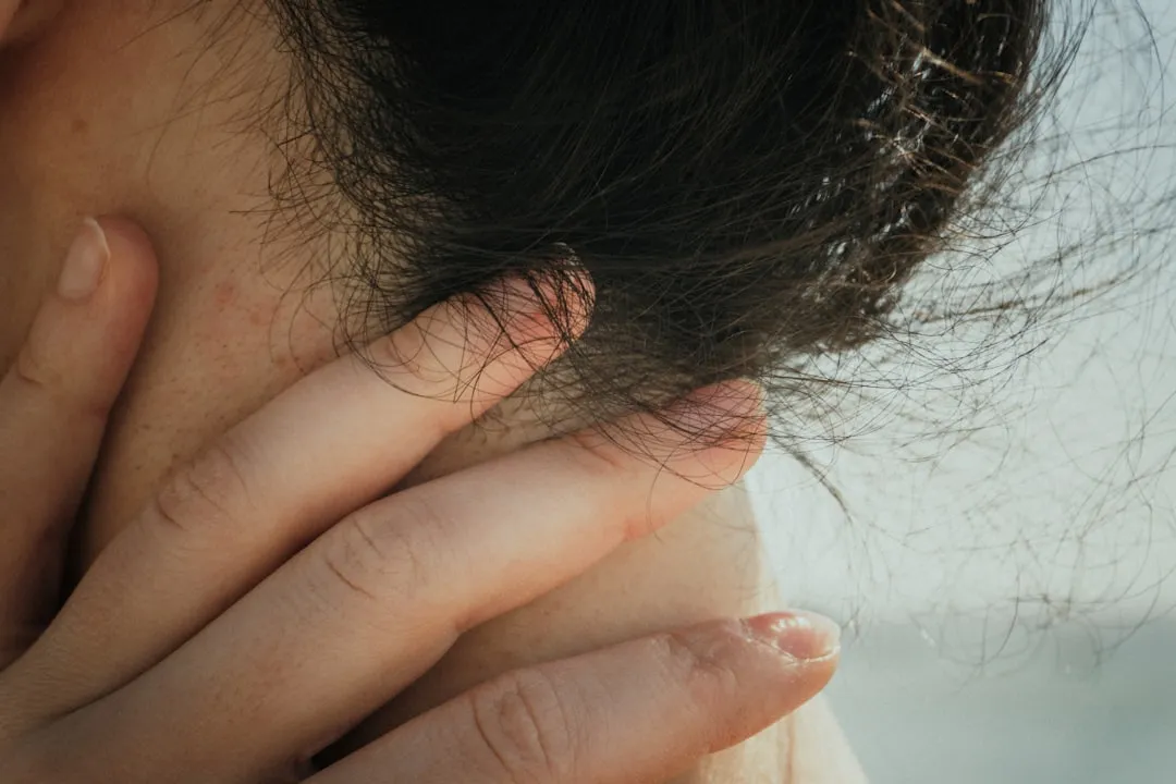 Uma mão toca suavemente o pescoço e o cabelo da pessoa.