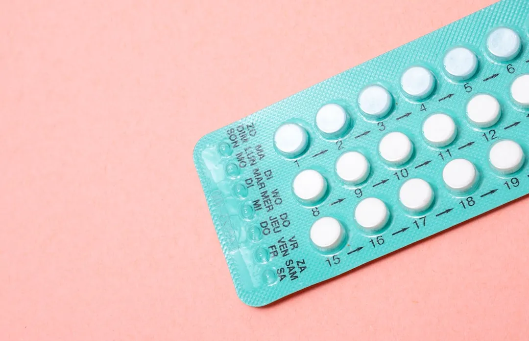 Acessibilidade a métodos contraceptivos via telemedicina. Cartela de pílulas anticoncepcionais em fundo azul.
