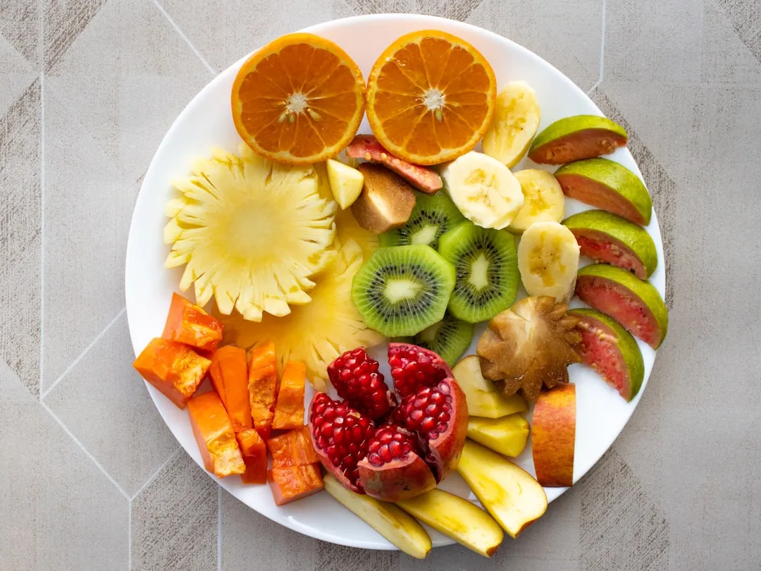 Um prato branco coberto com frutas cortadas