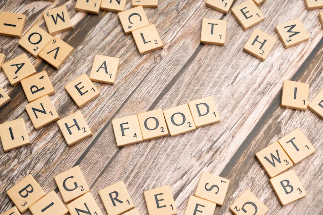 Peças de Scrabble formando a palavra 'HEALTH' sobre uma superfície de madeira