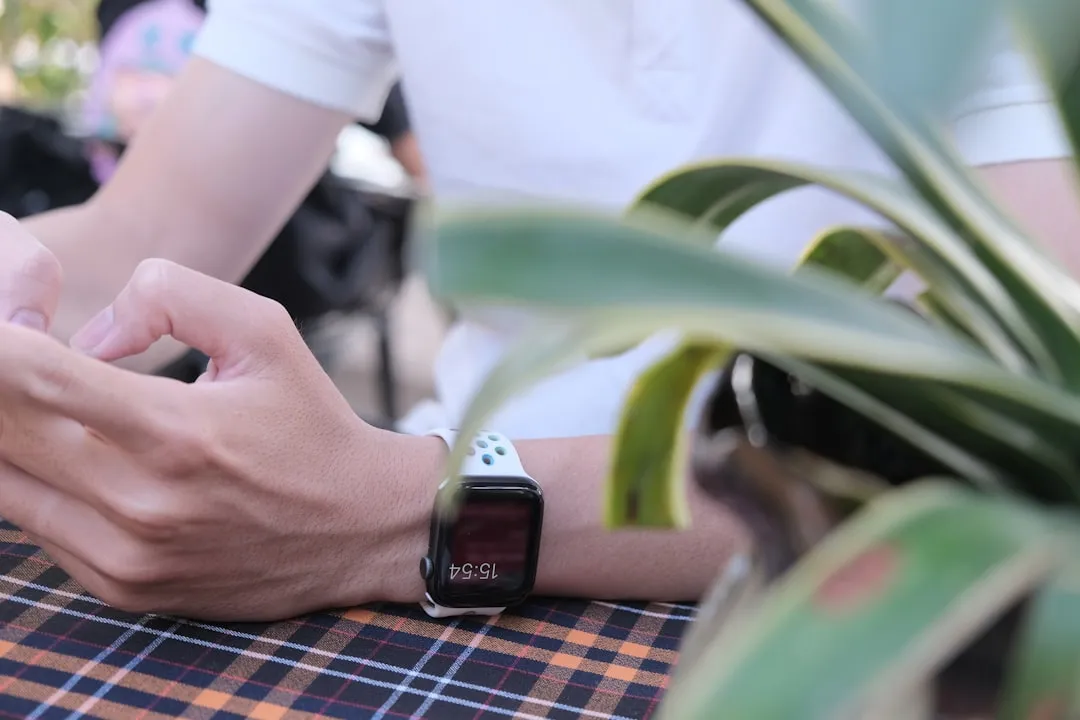 Pessoa usando estojo de alumínio prateado apple watch com banda esportiva branca Pessoa usando estojo de alumínio prateado apple watch com banda esportiva branca