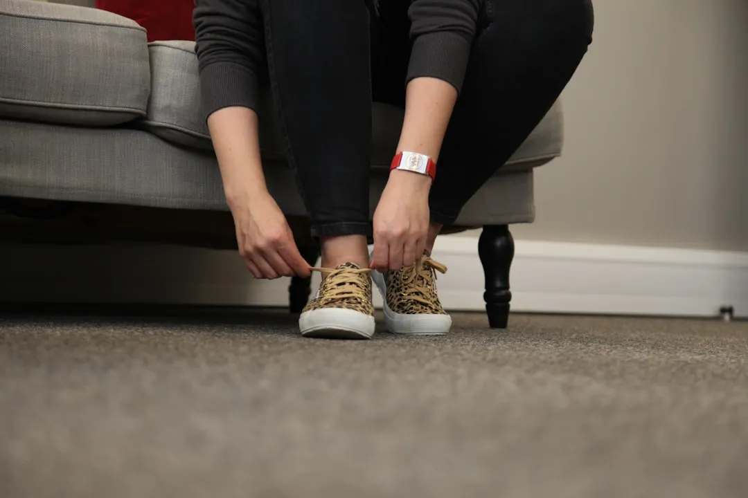 Mulher sentada em um sofá, possivelmente em repouso durante um processo de recuperação ortopédica.