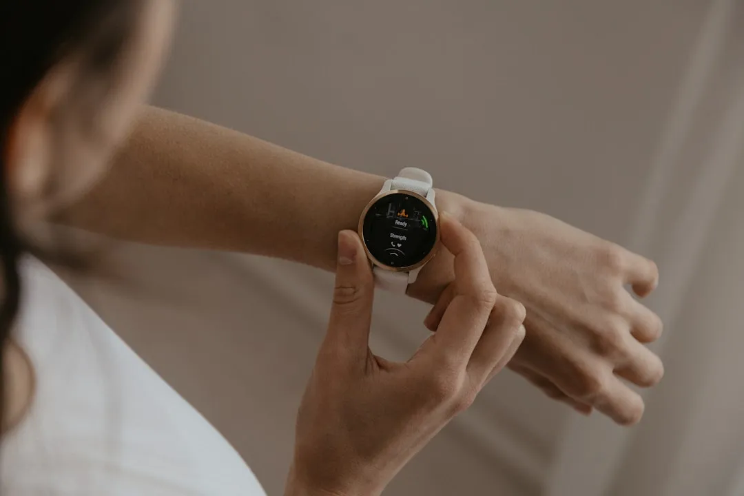 Tecnologia vestível como ferramenta de empoderamento do paciente Uma mulher segurando um relógio inteligente na mão, simbolizando o controle sobre sua saúde.