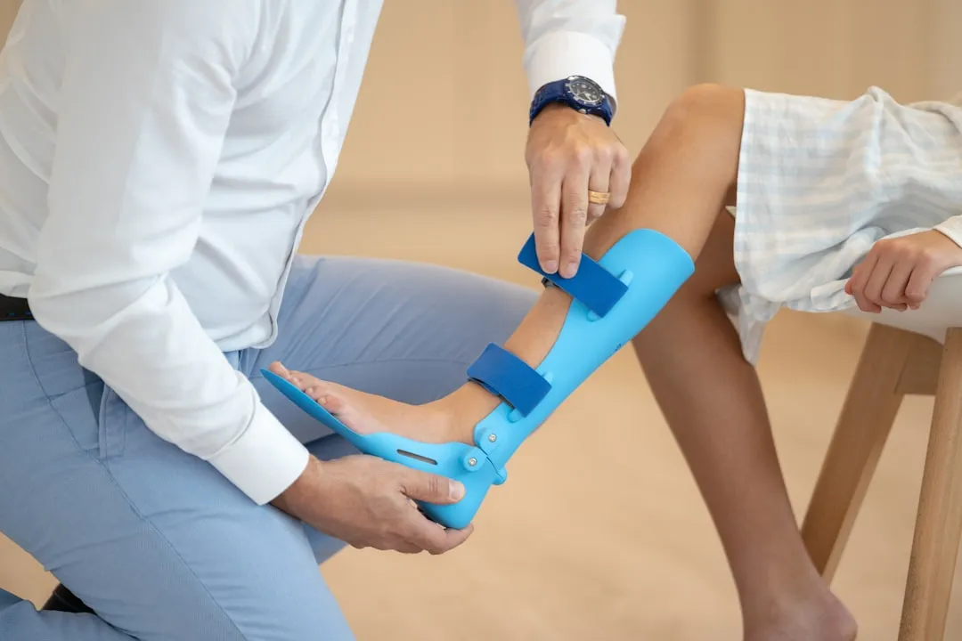 Uma pessoa sentada em uma cadeira com um pé em um elenco