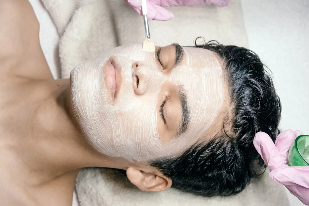 Um homem que está recebendo uma máscara facial no rosto