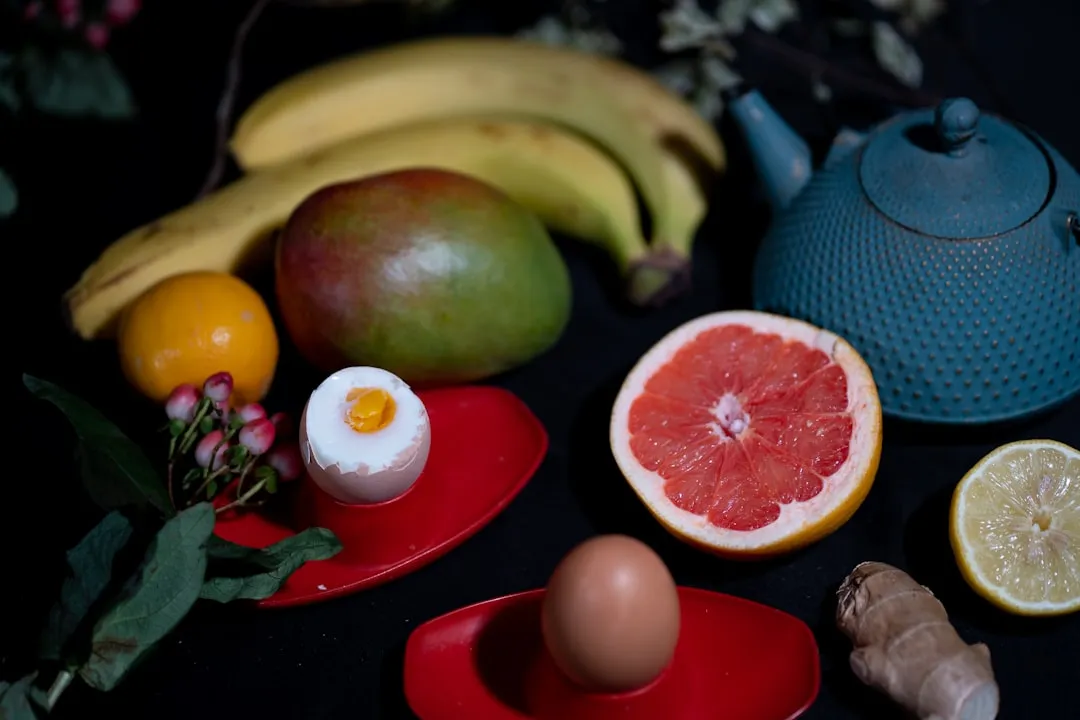 Fruta de maçã verde ao lado de frutas redondas vermelhas em placa de cerâmica vermelha Fruta de maçã verde ao lado de frutas redondas vermelhas em placa de cerâmica vermelha