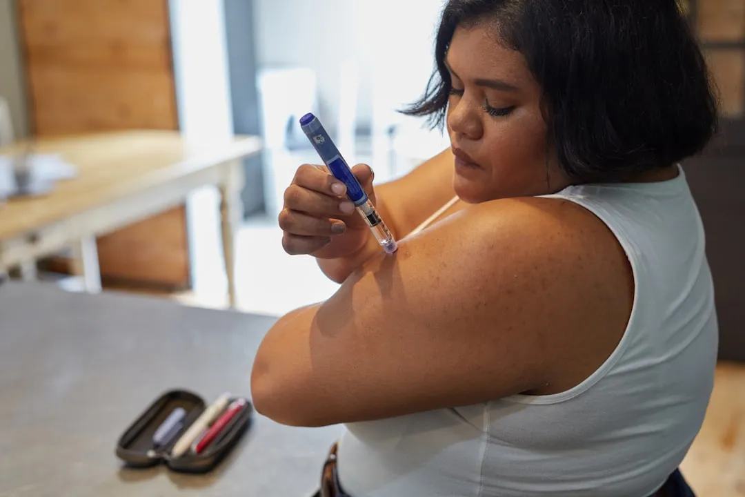 Tecnologia como aliada no controle de condições de saúde Pessoa utilizando uma caneta de aplicação de insulina, representando o controle da saúde.
