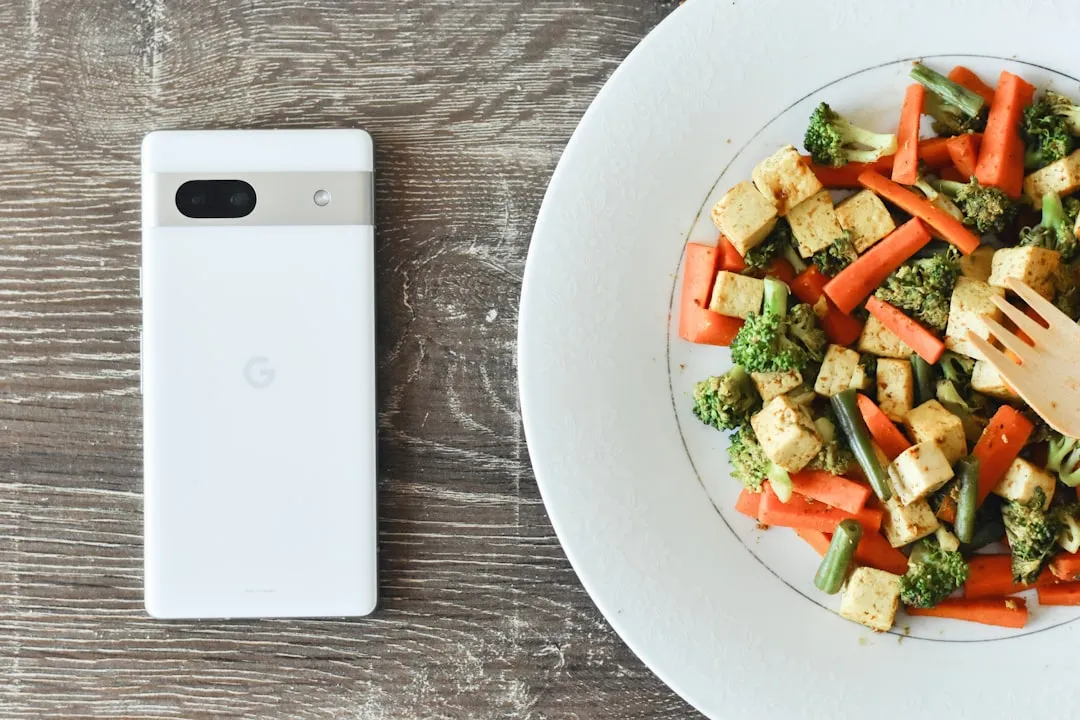 Um prato de comida com um telefone celular ao lado dele Um prato de comida com um telefone celular ao lado dele