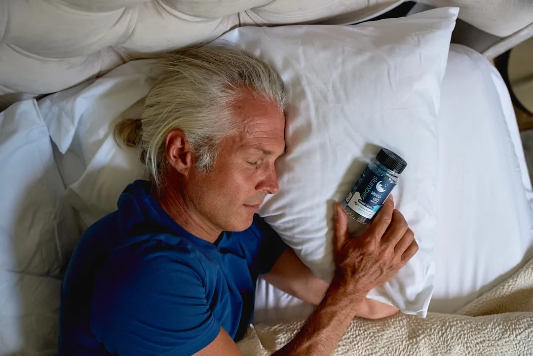 Um homem deitado na cama segurando um telefone celular Um homem deitado na cama segurando um telefone celular