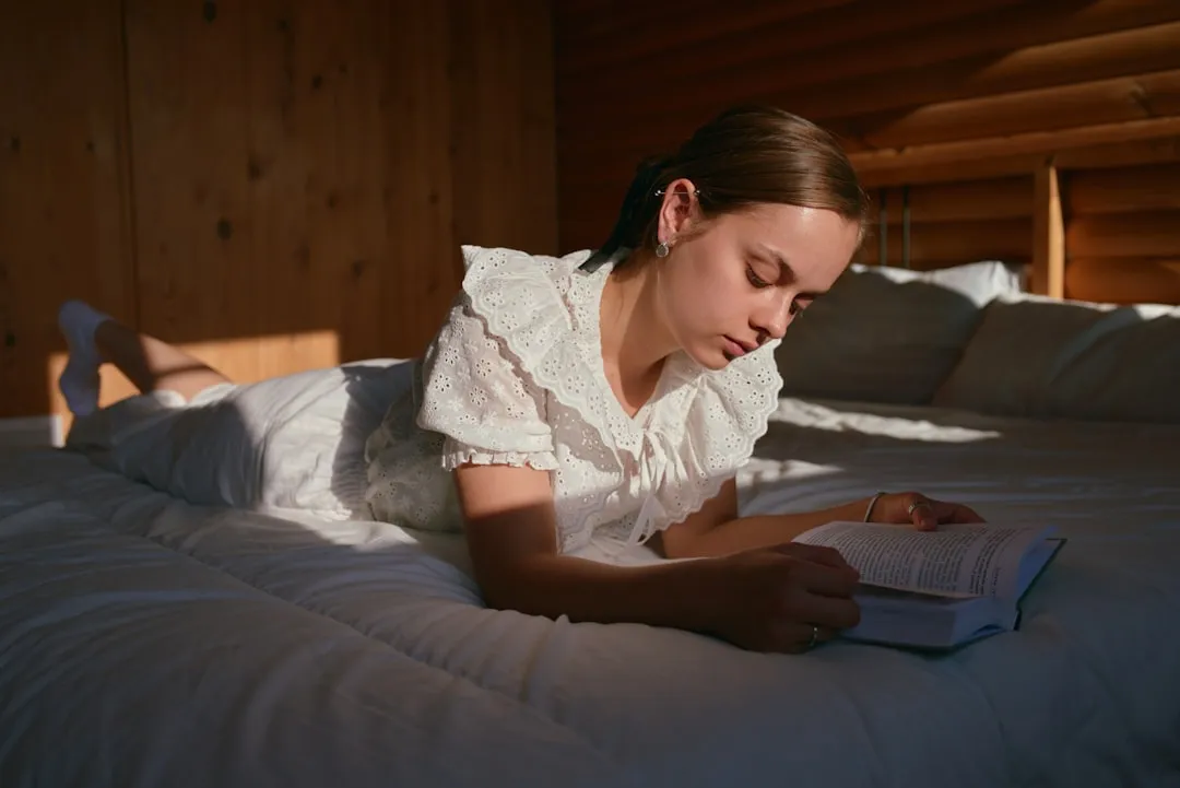 Uma mulher deitada em uma cama lendo um livro