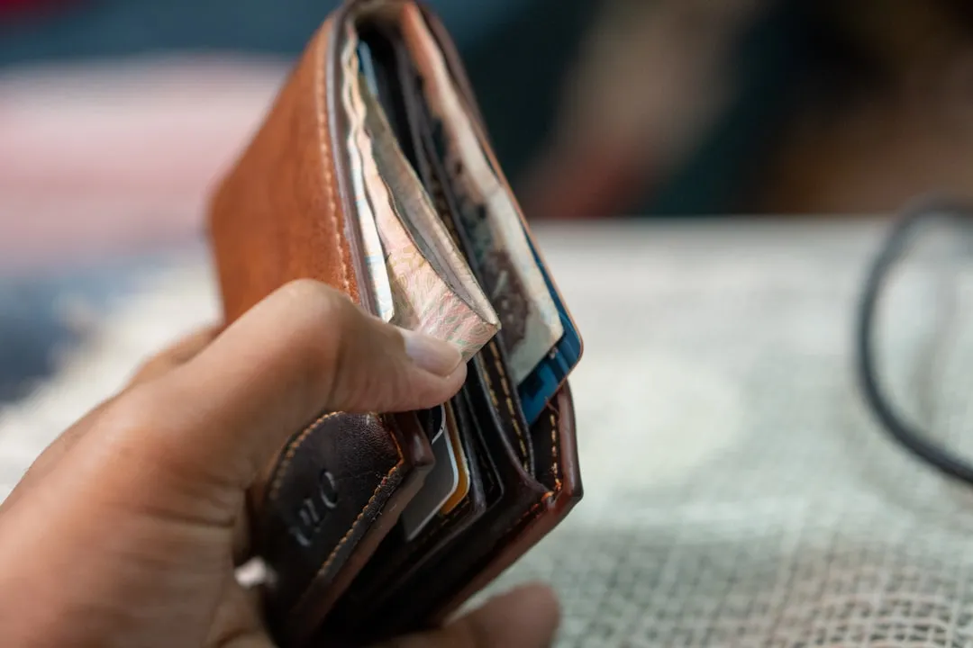 Uma pessoa segurando uma carteira na mão
